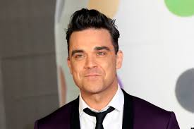 Robbie Williams stringe le mani ai fans e poi compie un gesto che nessuno si aspettava, il pubblico interdetto