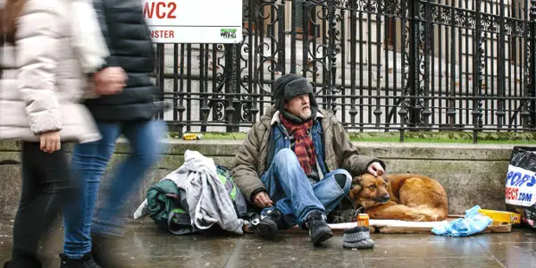 Un clochard chiede qualche spicciolo ad un ragazzo che gli presta la sua carta di credito