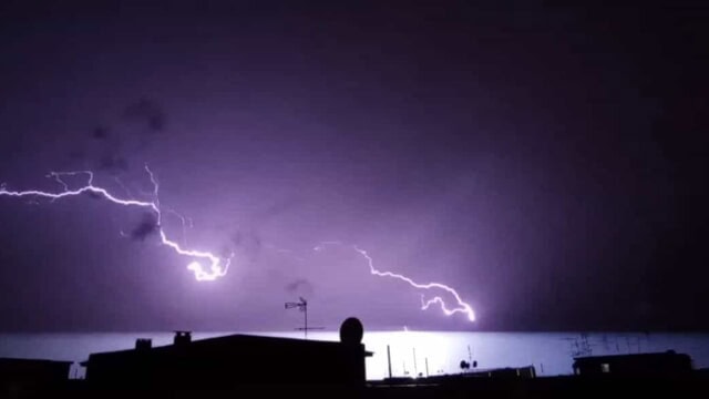 Fulmine durante la tempesta notturna sopra la città, evento meteorologico intenso e spettacolare.