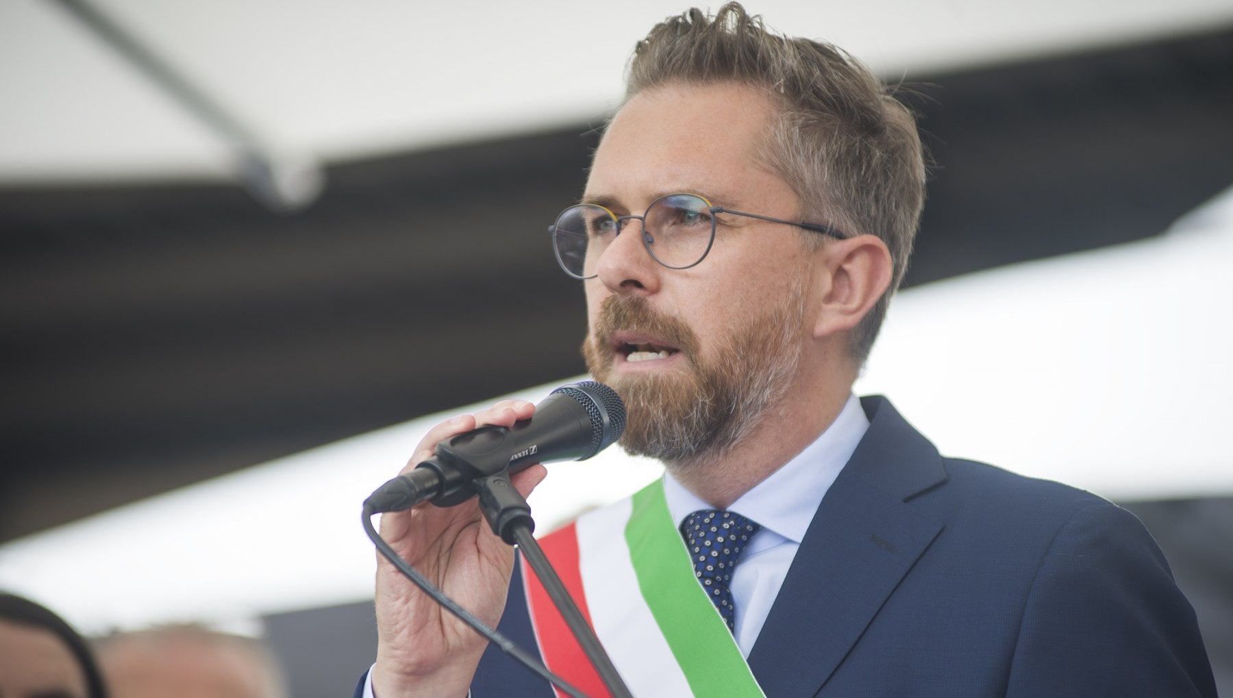 Dal palco della protesta contro gli accorpamenti scolastici, il sindaco di Bologna accusa il governo di colpire le regioni non allineate a Fratelli d’Italia.